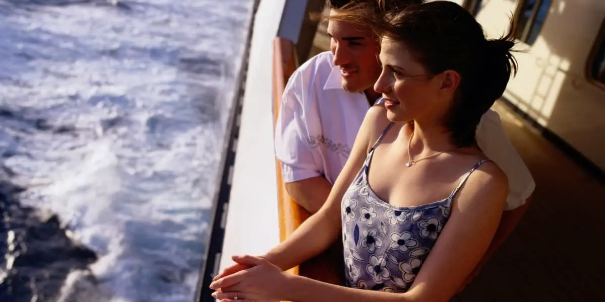 couple leaning on a cruise ship railing